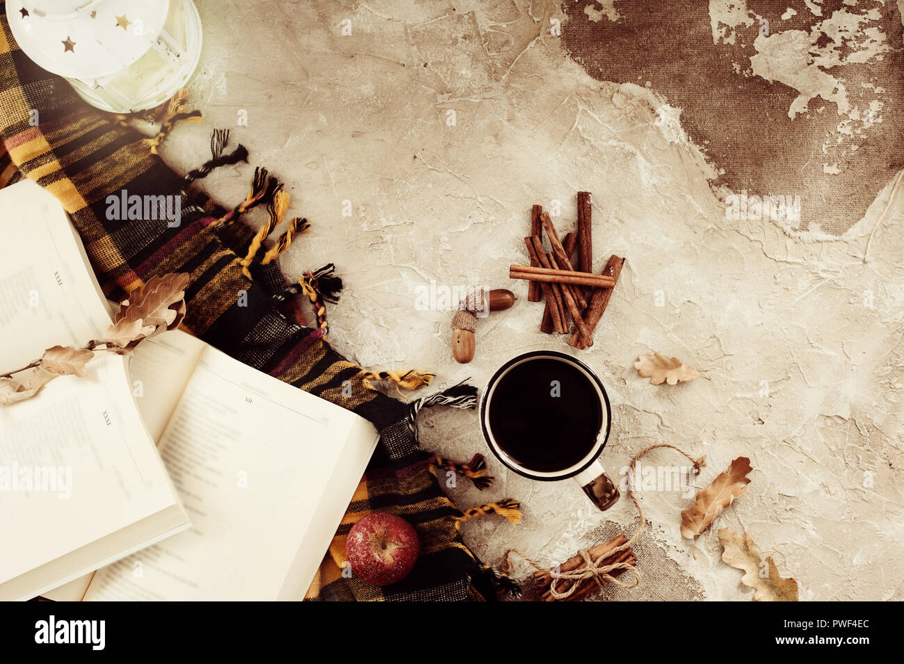 Composizione d'autunno. Tazza di caffè, coperta, foglie di autunno, bastoncini di cannella su sfondo beige. Appartamento laico, vista dall'alto. Foto Stock