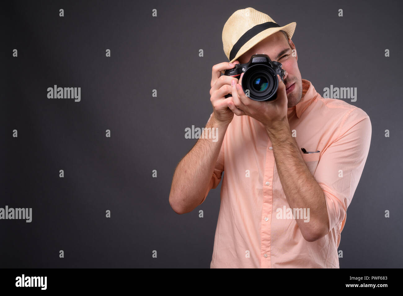 Bel giovane turista uomo contro uno sfondo grigio Foto Stock