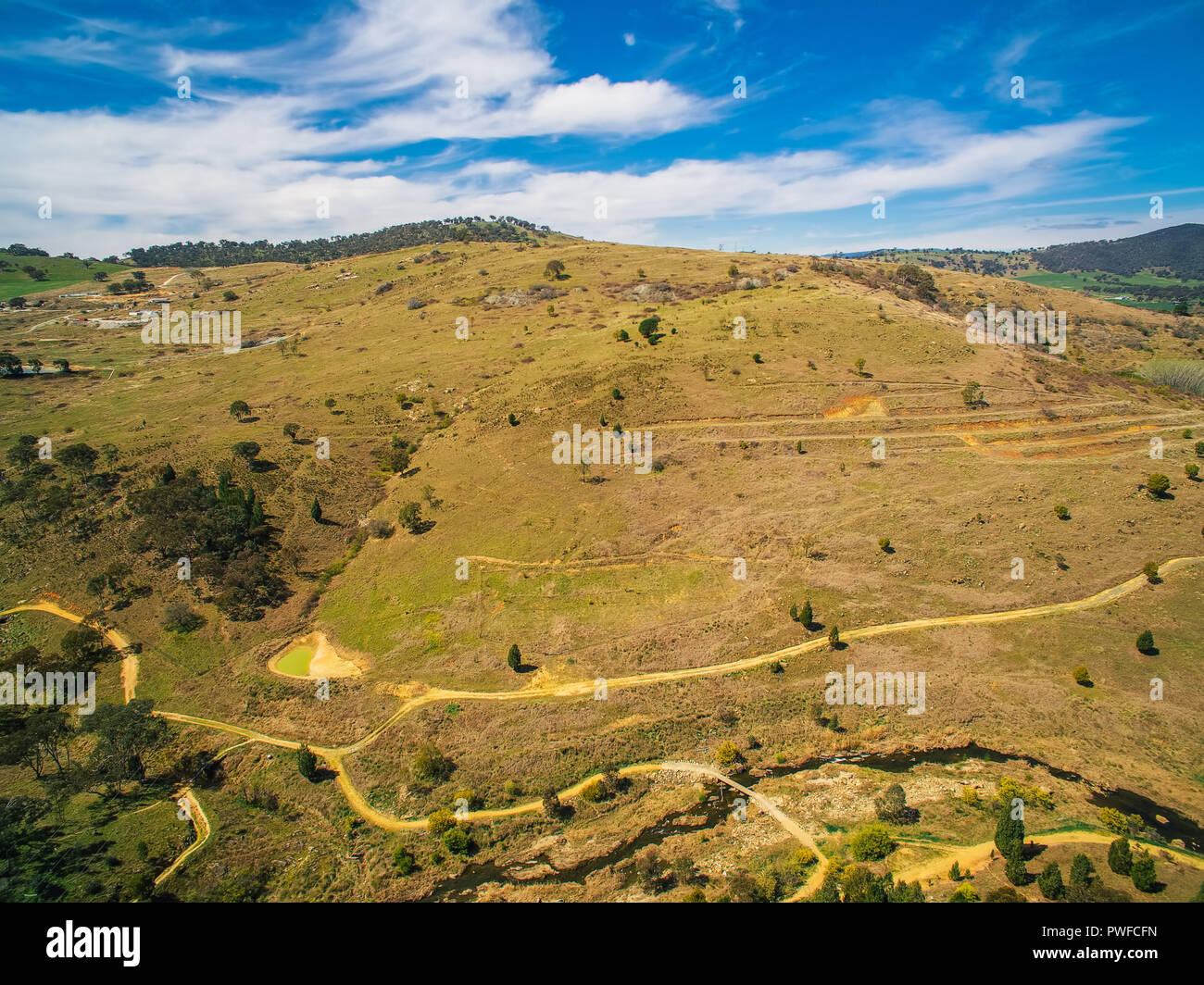 Strade sterrate e colline erbose in campagna australiana Foto Stock