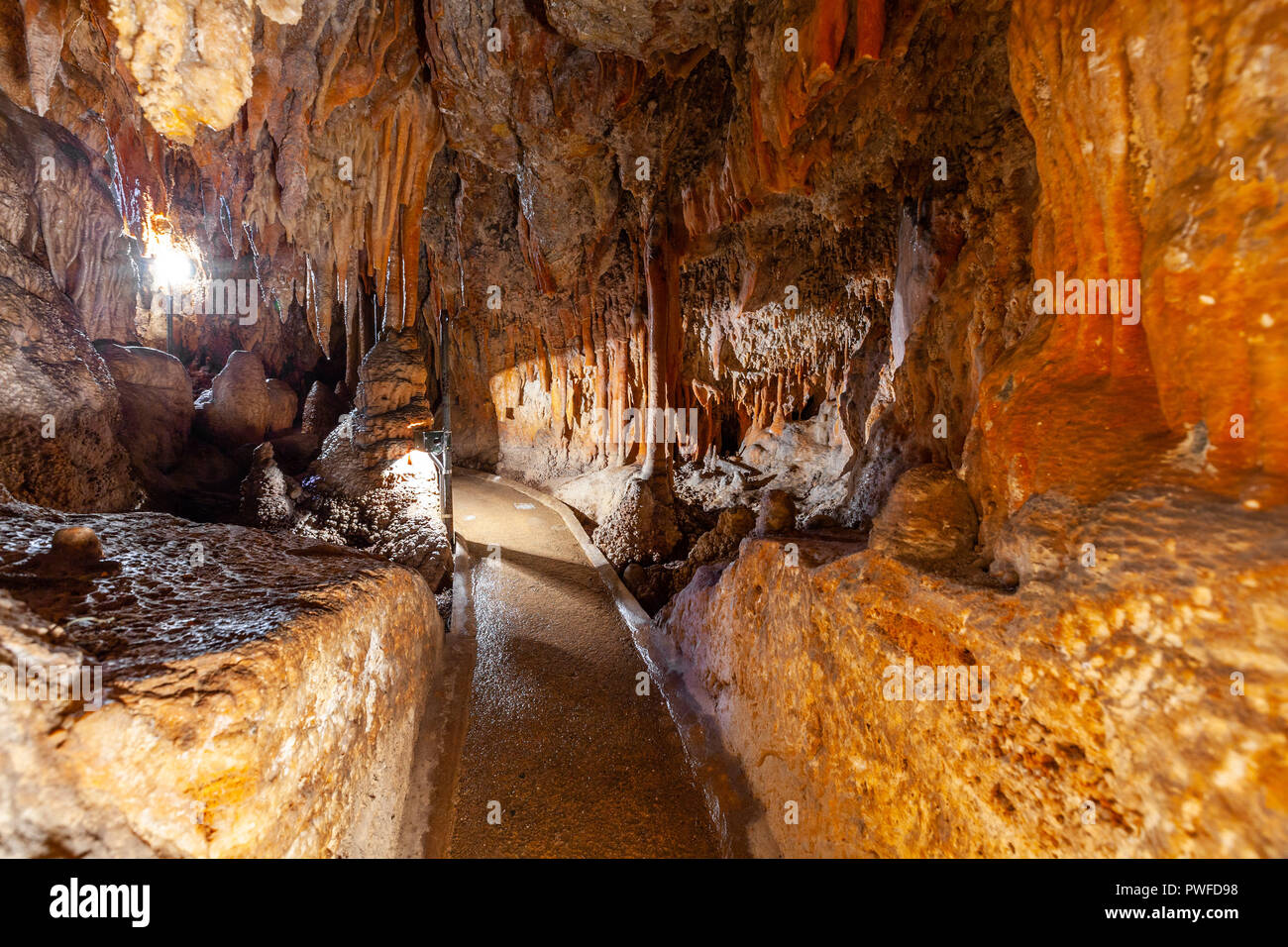 Percorso a piedi tra stalattiti e stalagmiti in una grotta in Australia Foto Stock