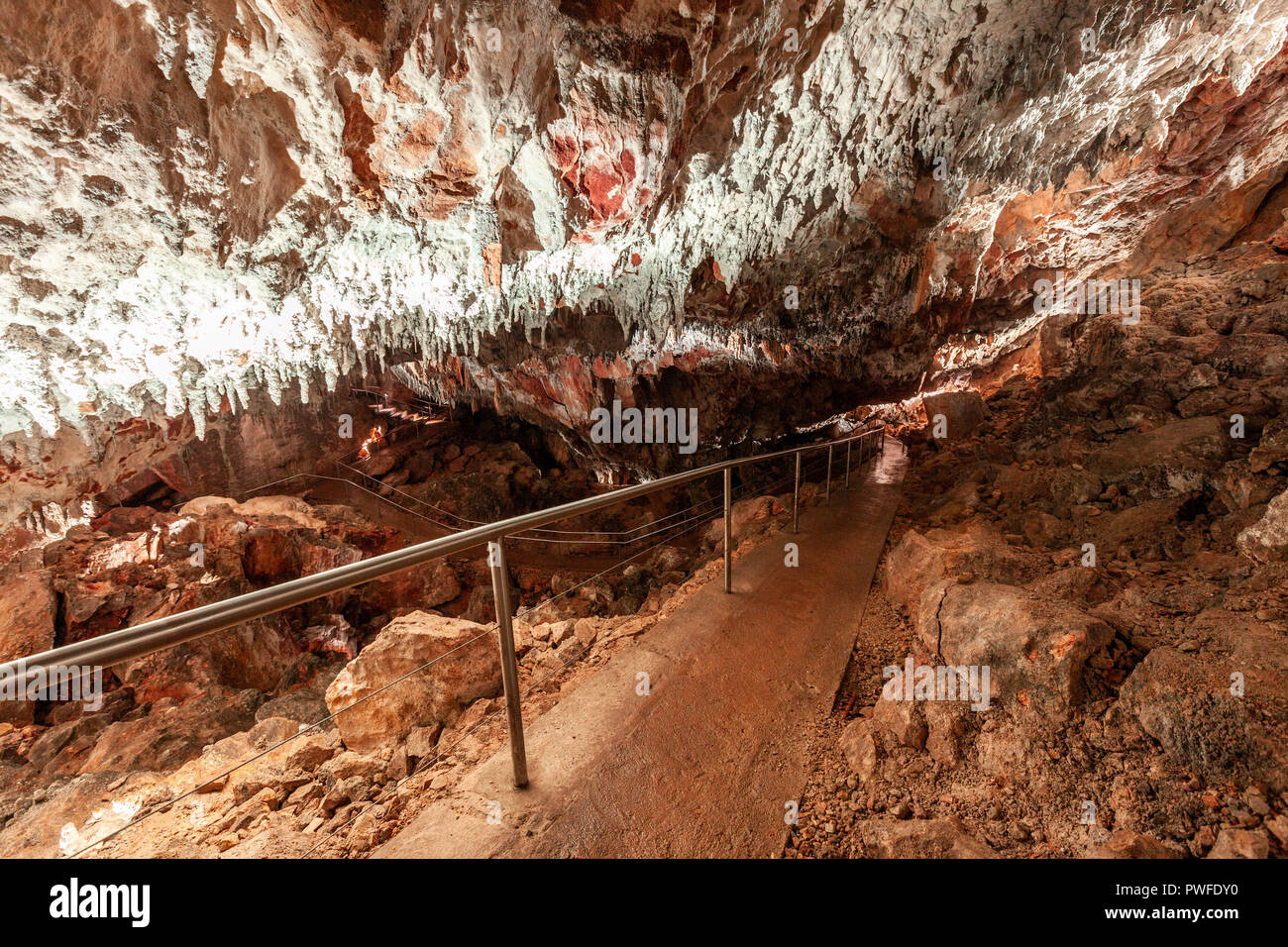 Il sentiero che conduce verso il basso sotto la grotta di pietra calcarea soffitto basso nel Kosciuszko National Park, Australia Foto Stock