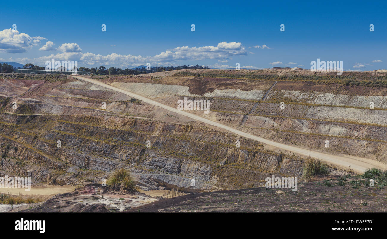 Strada sterrata che conduce alla miniera di calcare attraverso strati di terreno Foto Stock