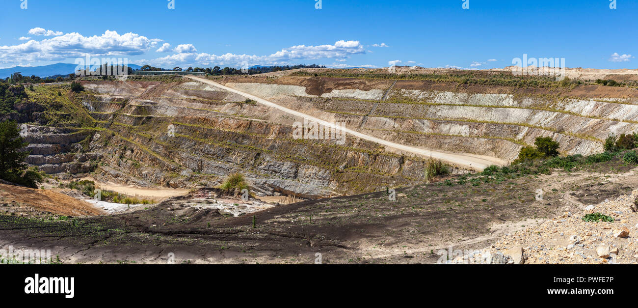 Paesaggio panoramico di strada sterrata che conduce alla miniera di calcare attraverso strati di terreno Foto Stock