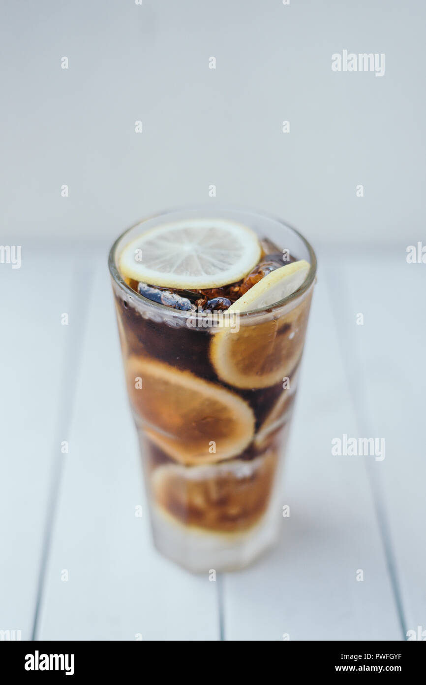 Iced Cola di vetro con le fette di limone decorazione Foto Stock