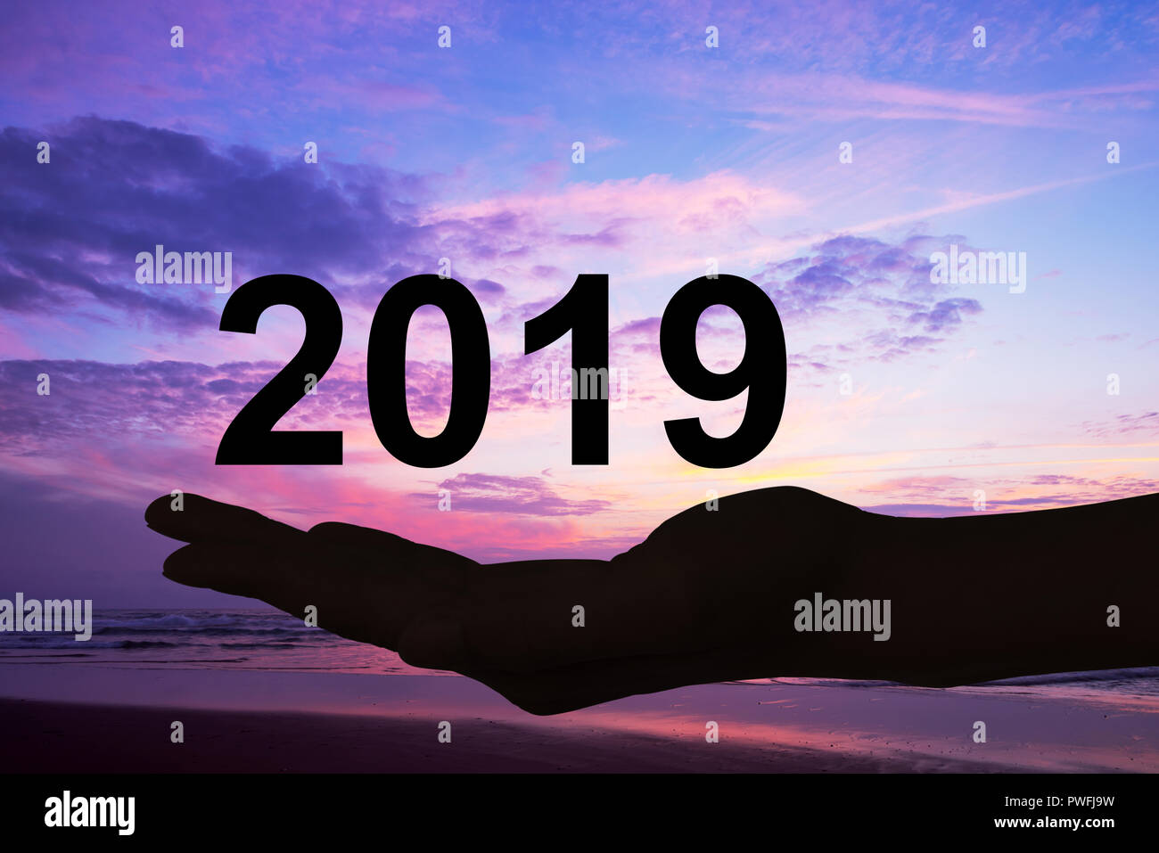 Offerta di mano 2019 numeri, sfondo al tramonto Foto Stock
