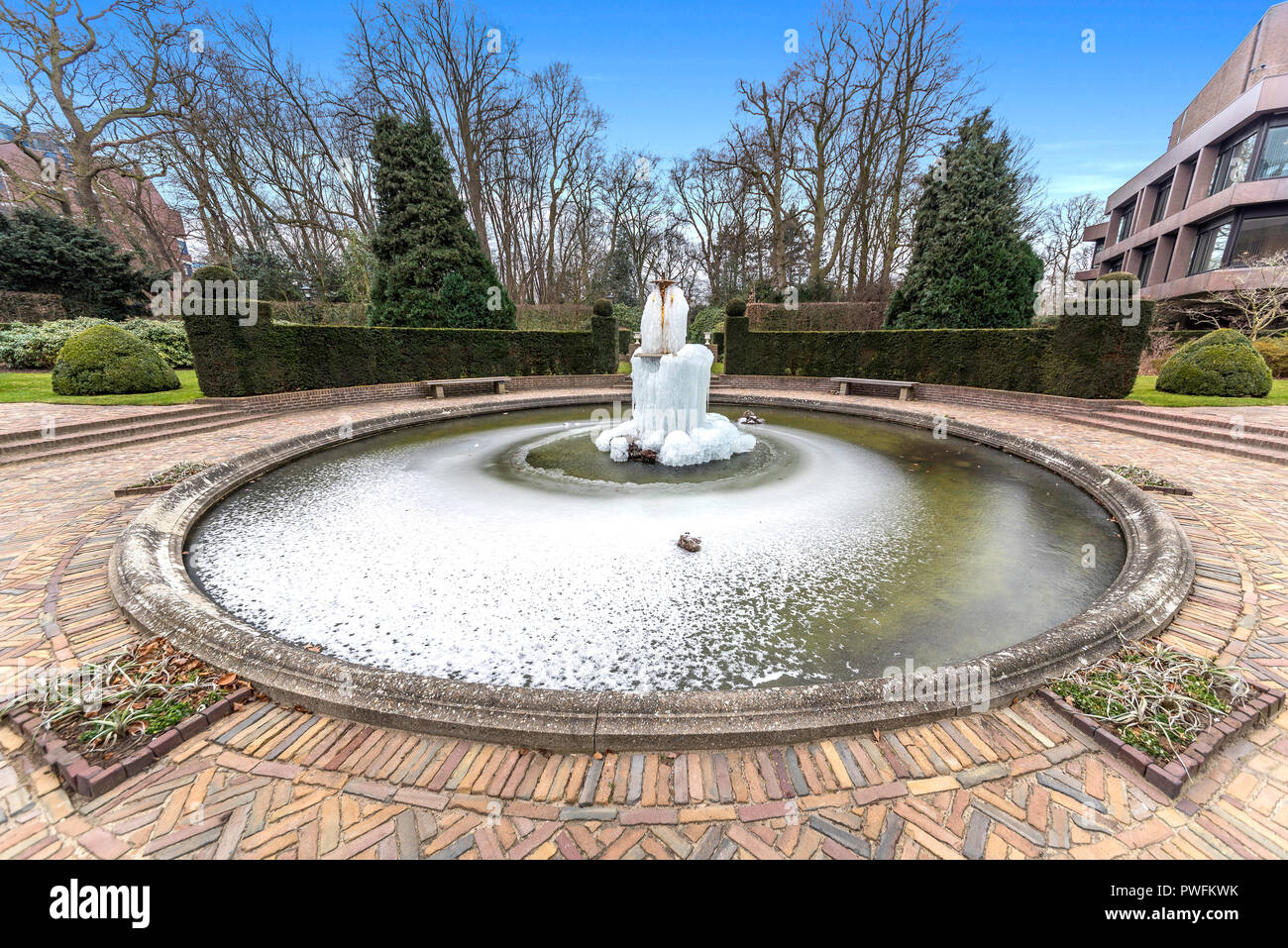 Freddo e congelati acqua fontana nel mezzo dello stagno e di un bellissimo giardino Foto Stock