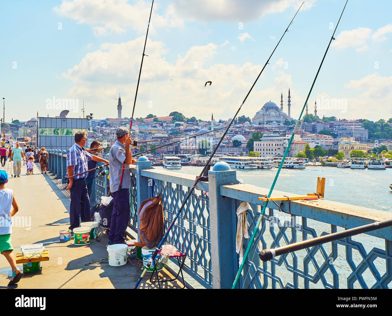 I cittadini sul ponte Galata la pesca nella bocca del Golden Horn Bay, e una vista del quartiere Eminonu skyline in background. Istanbul. Foto Stock