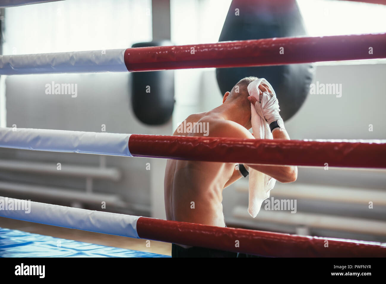 Boxer tergi sudore con asciugamano dopo dura lotta in seduta pugilato ring Foto Stock