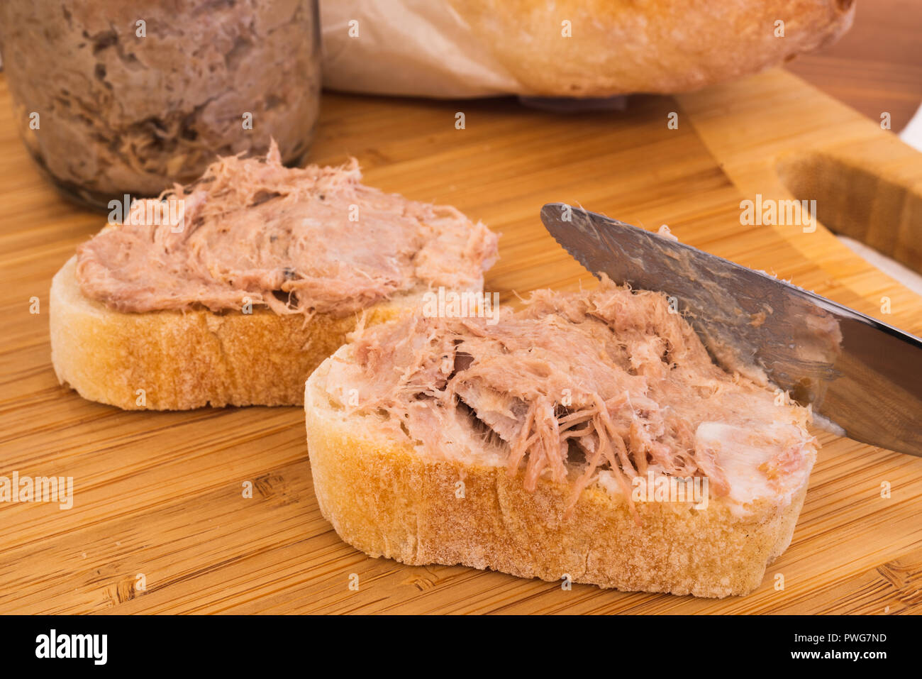 Due fatti in casa Rillettes carne francese diffuso fatto di carne di maiale su una baguette di pane e spalmatura a coltello le rillettes Foto Stock