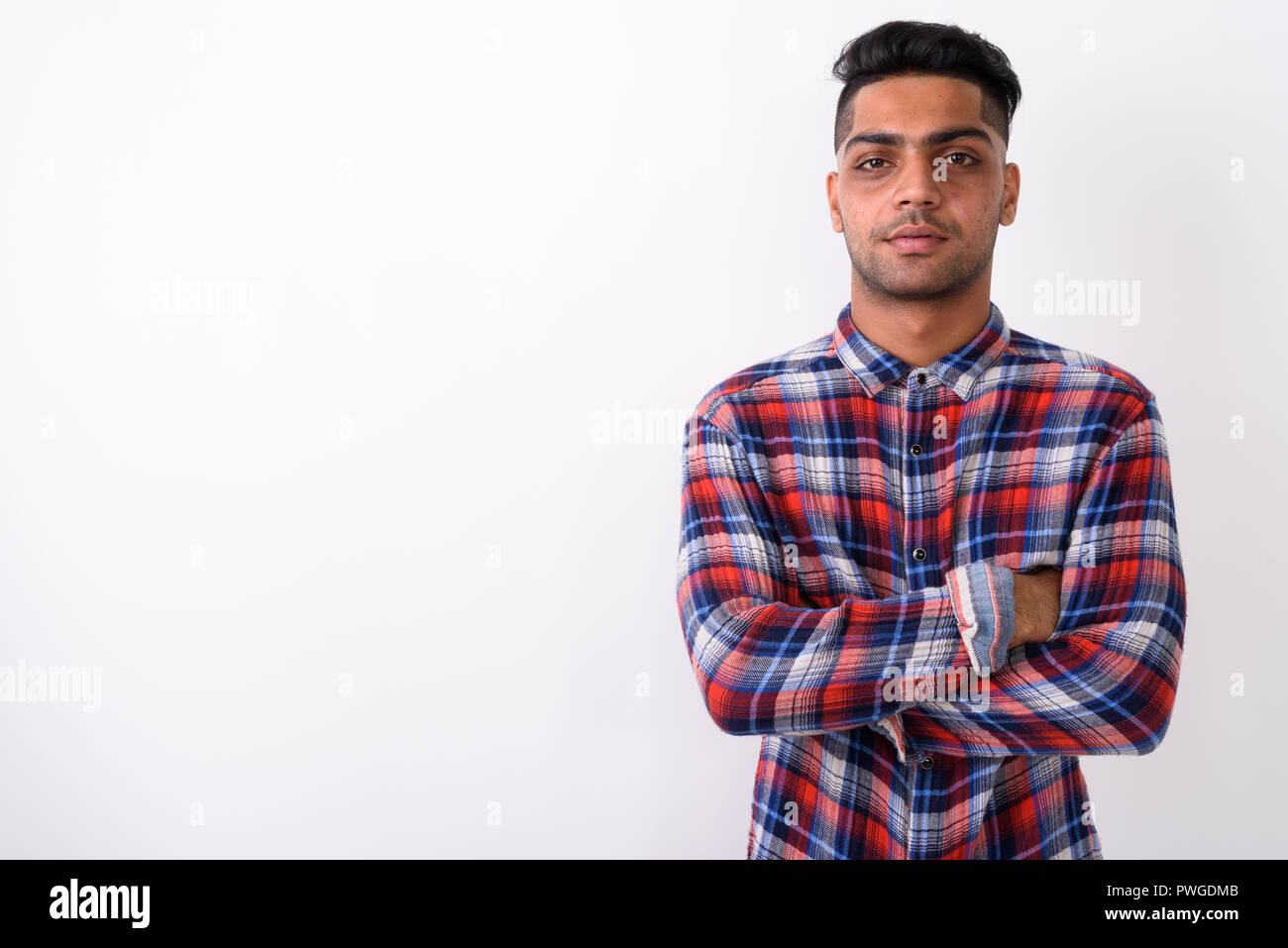 Giovani indiani uomo indossa camicia a scacchi contro backgroun bianco Foto Stock