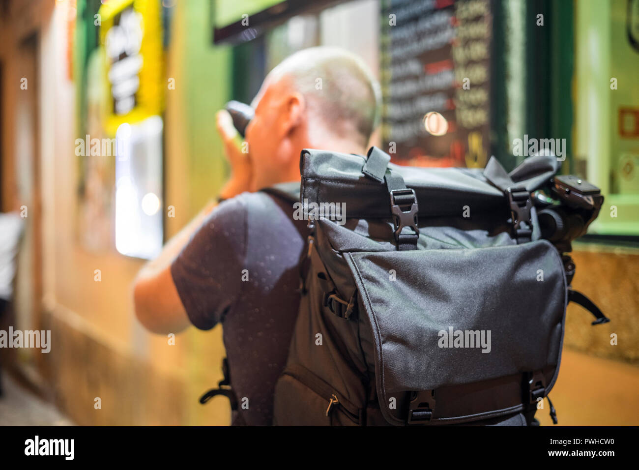 Fotografo di scattare le foto di vivaci strade con ristoranti di Alfama, Lisbona, Portogallo Foto Stock