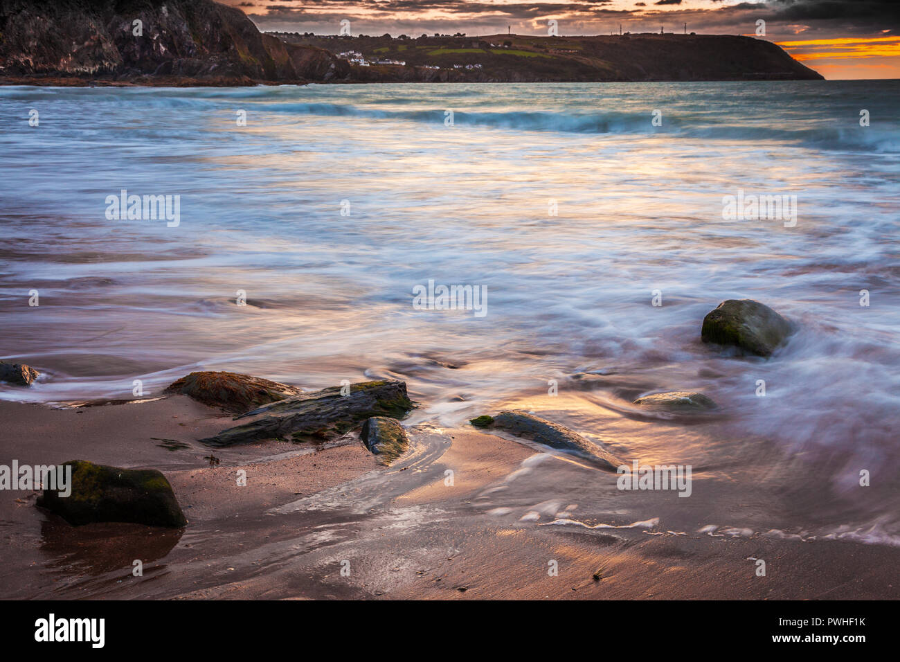 Tramonto sulla spiaggia di Tresaith in Ceredigion, Galles, guardando verso Aberporth. Foto Stock