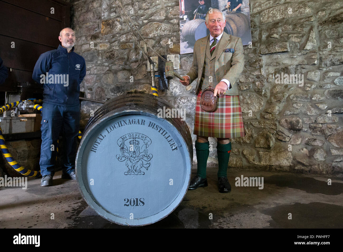 Il Principe di Galles, noto come il Duca di Rothesay mentre in Scozia, riempie un nuovo whisky botte, al fianco di operatore senior Ryan Cromar, durante una visita al Royal Lochnagar Distillery a Crathie sulla Royal Deeside. Foto Stock