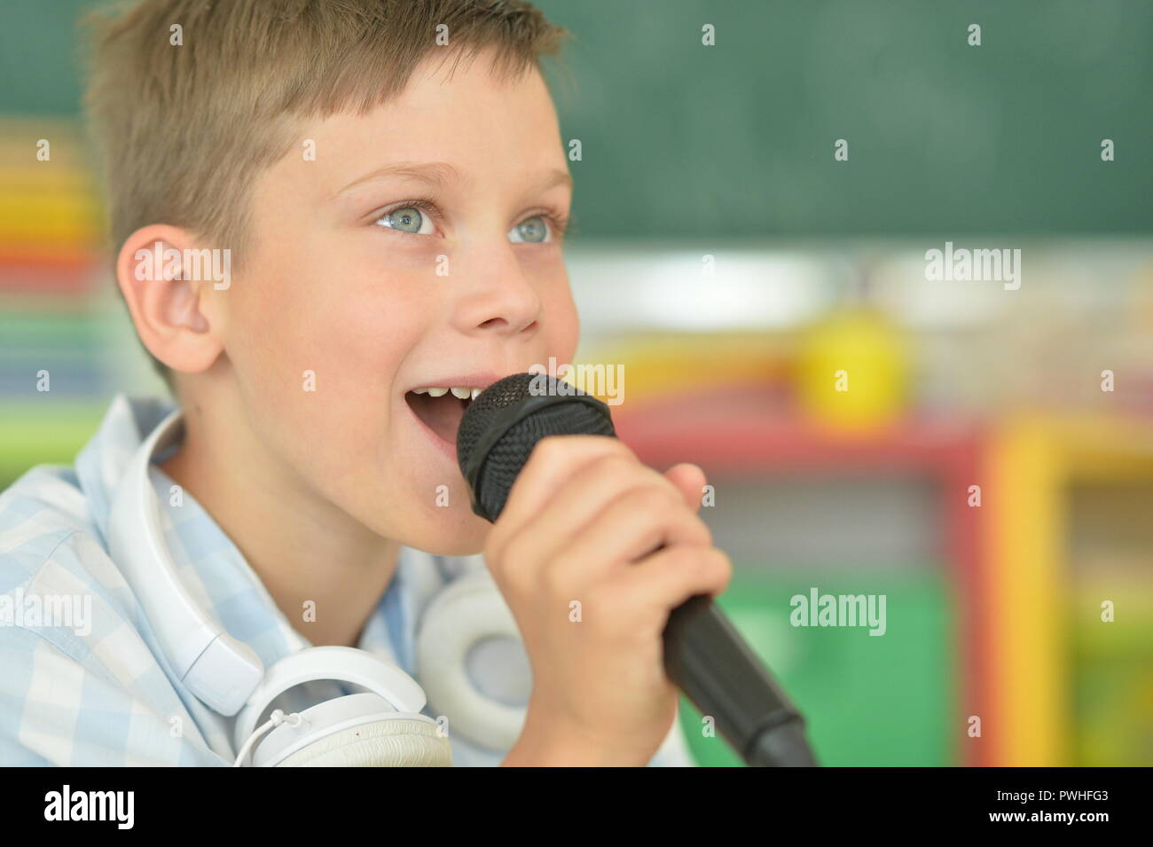 Ritratto di un ragazzo simpatico cantando il karaoke Foto Stock