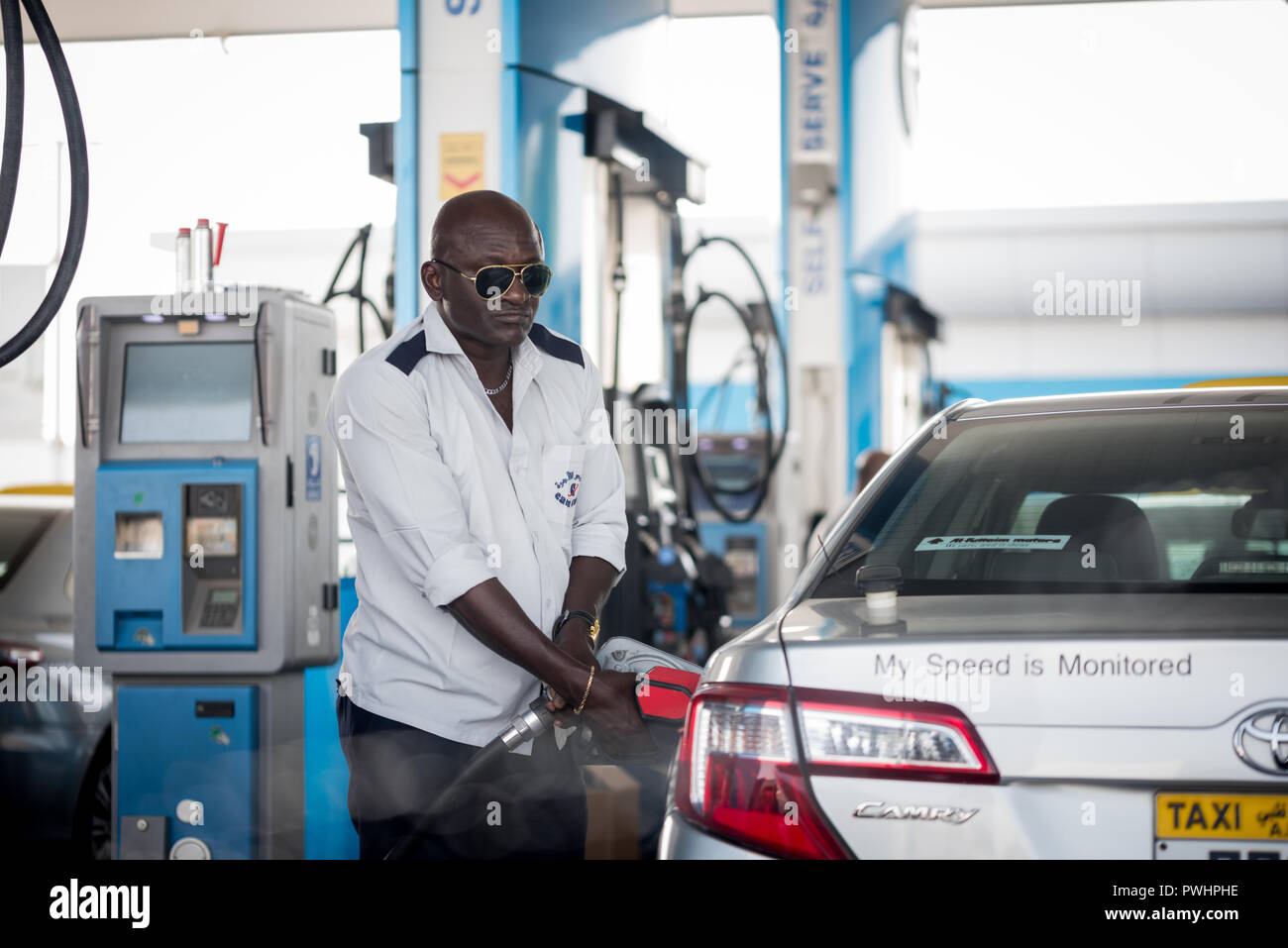 Set 18, 2018:un Driver africana negli EMIRATI ARABI UNITI alimentando il suo taxi a ADNOC Self Service, Abu Dhabi Emirati arabi uniti Foto Stock