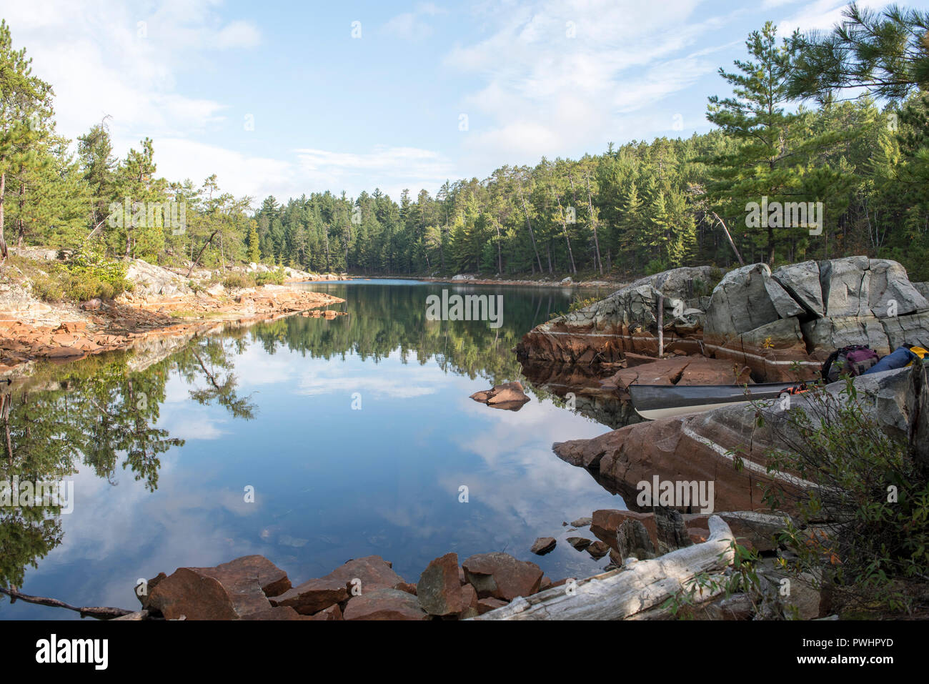Vista la mattina della ancora acque di un piccolo lago nel Temagami, Ontario, Canada. La bellezza del canadese scudo. Foto Stock