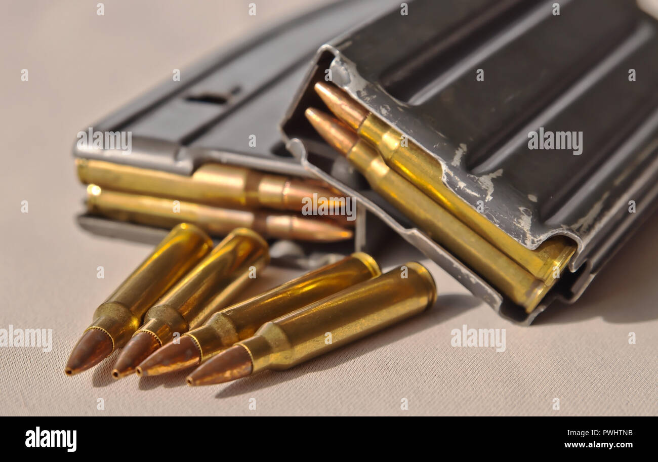 Due fucile in metallo riviste impilati uno sull'altro, caricato con calibro .223 pallottole con quattro ulteriori proiettili dello stesso calibro di fronte Foto Stock