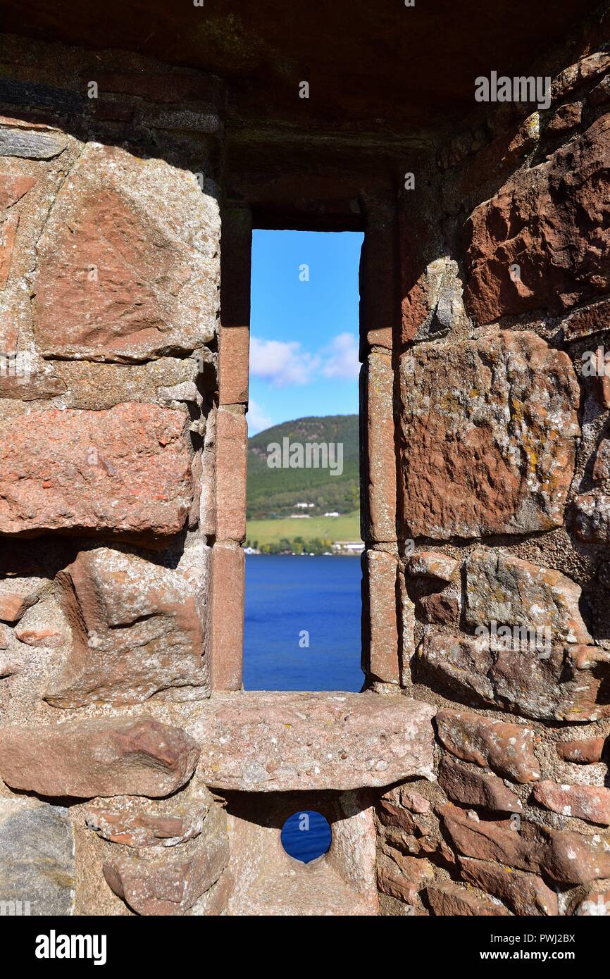Drumnadrochit, Highlands, Scotland, Regno Unito. Una vista attraverso una finestra al Castello Urquhart di Loch Ness e delle highlands . Foto Stock