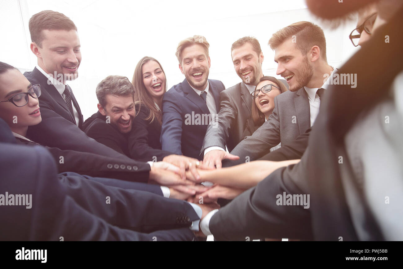 Un folto gruppo di persone di affari in piedi con le mani piegate insieme Foto Stock