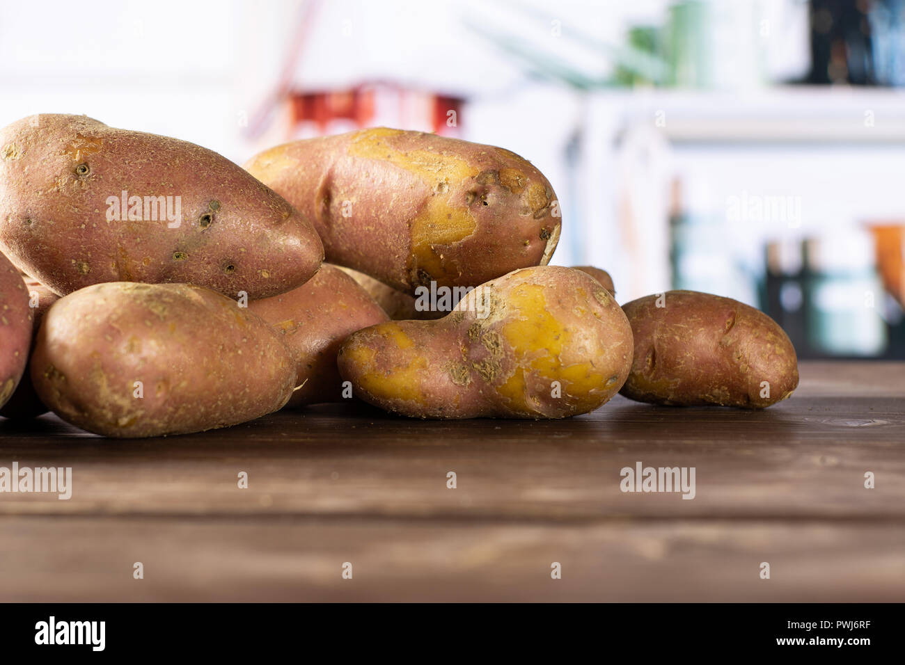 Sacco di intere fresche patata rossa francelina varietà con cucina grigio in background Foto Stock