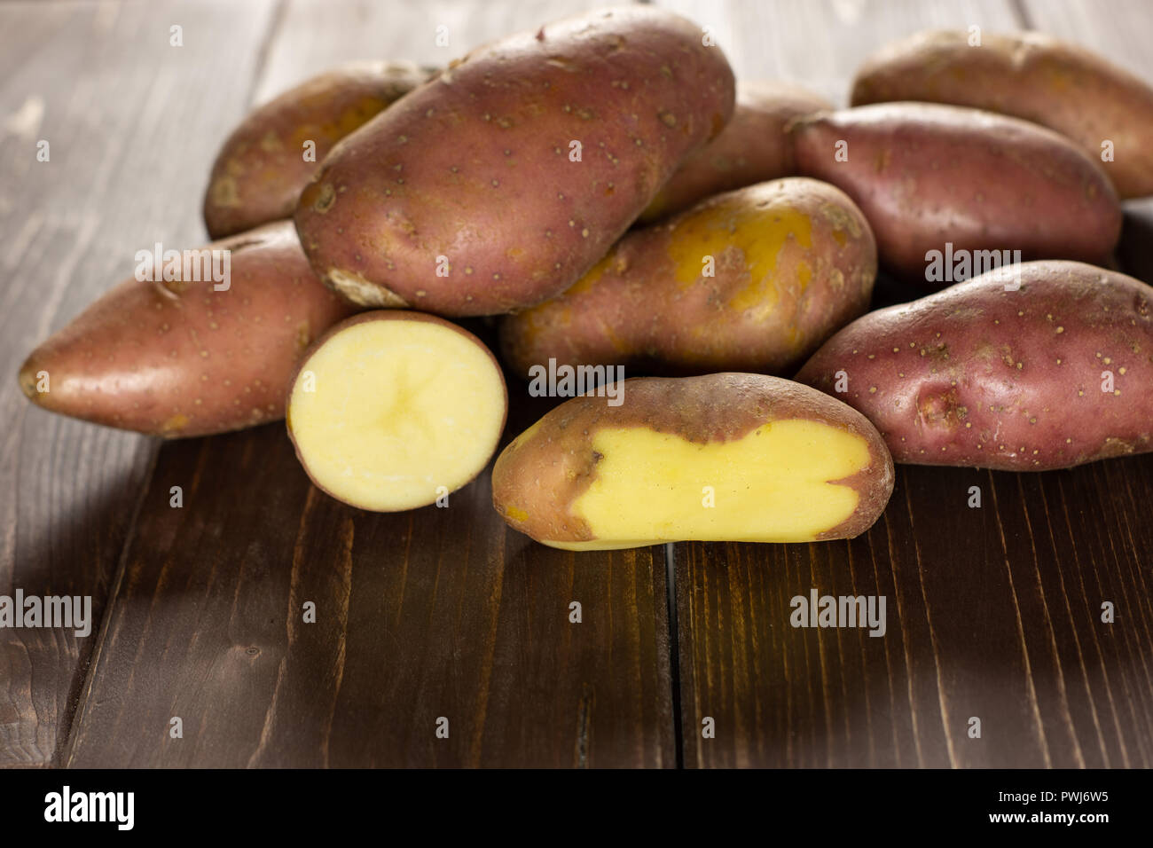 Sacco di intere fresche patata rossa francelina varietà su legno marrone Foto Stock