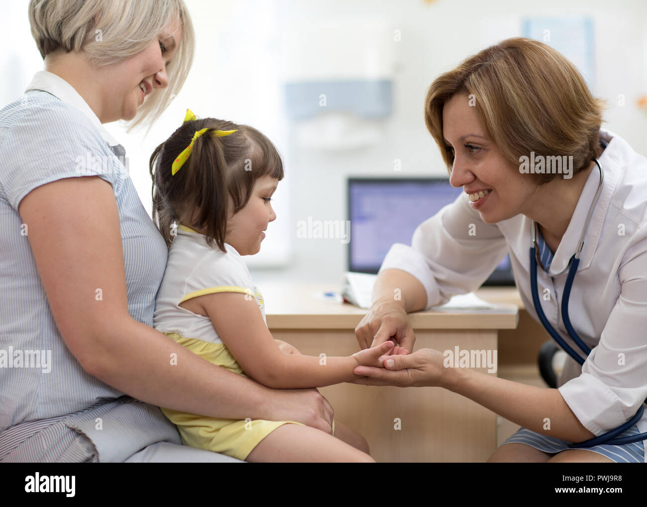 Bambino ragazza seduta sulla madre di giri visita medico nel centro medico Foto Stock