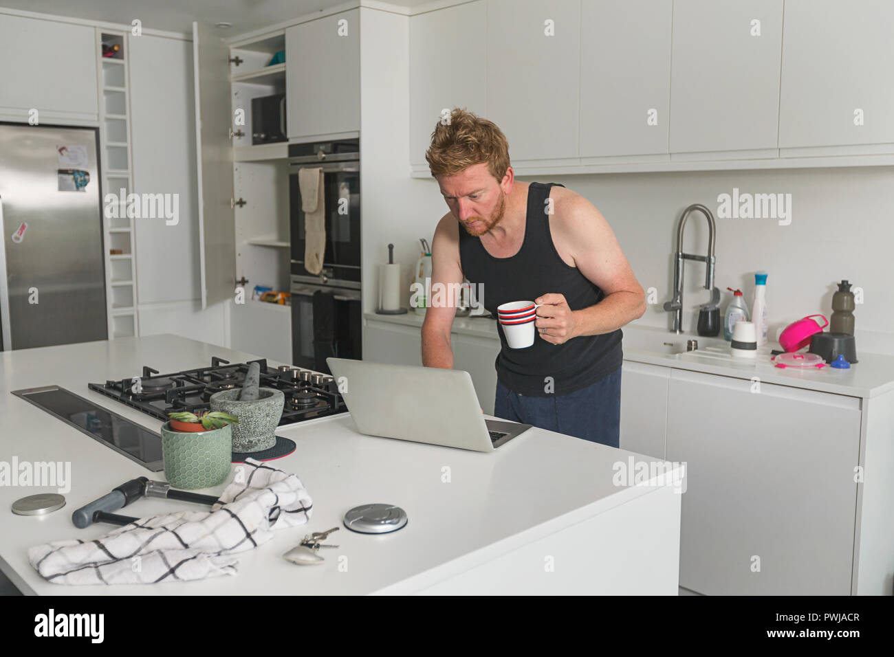 L'uomo controllo portatile con il caffè del mattino Foto Stock