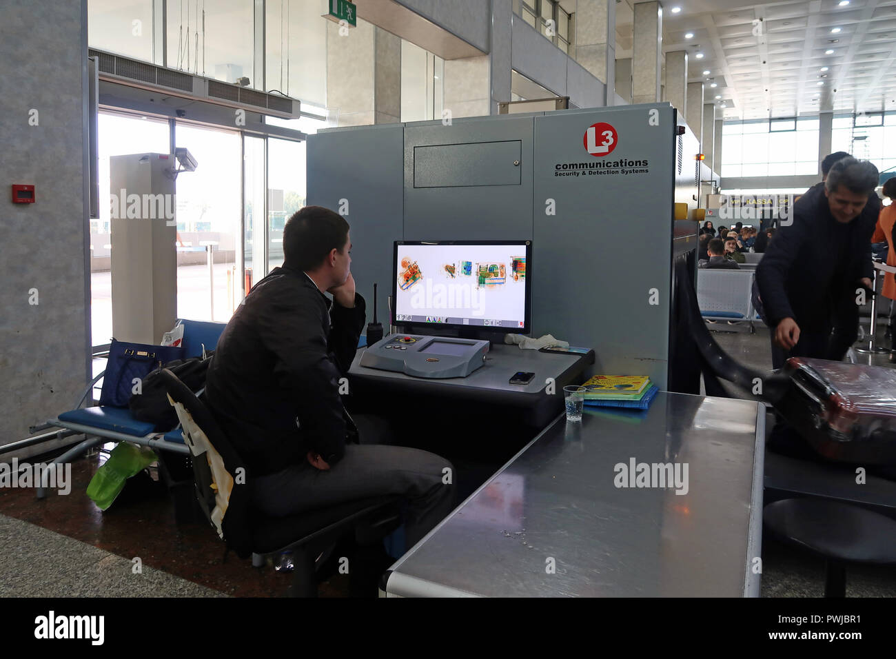 Un agente di sicurezza guarda un monitor scanner bagagli presso l'aeroporto internazionale di Tashkent Yuzhny, capitale dell'Uzbekistan Foto Stock