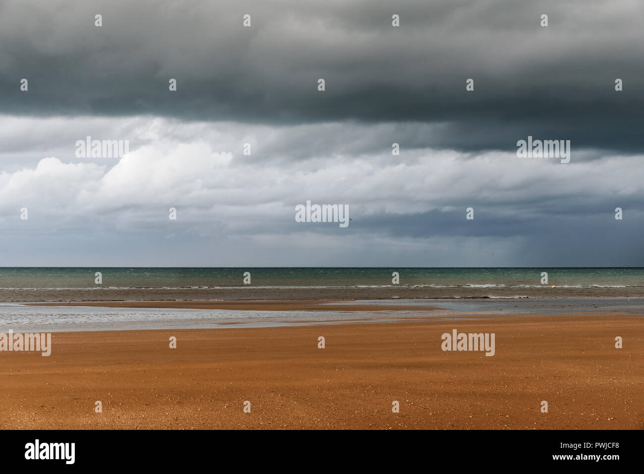 Costa francese, l'autunno. Le nubi sono così bassa in corrispondenza di un punto, che sembrava che la pioggia li collega al mare. La marea è molto bassa con i patche Foto Stock