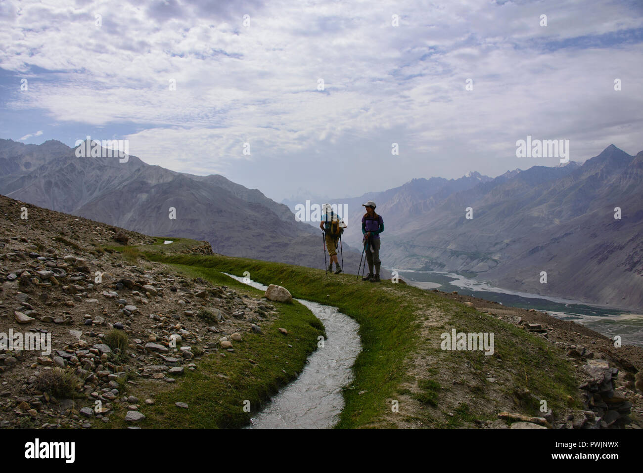 Trekking lungo un canale di irrigazione di Engel's Peak, Langar, Tagikistan Foto Stock