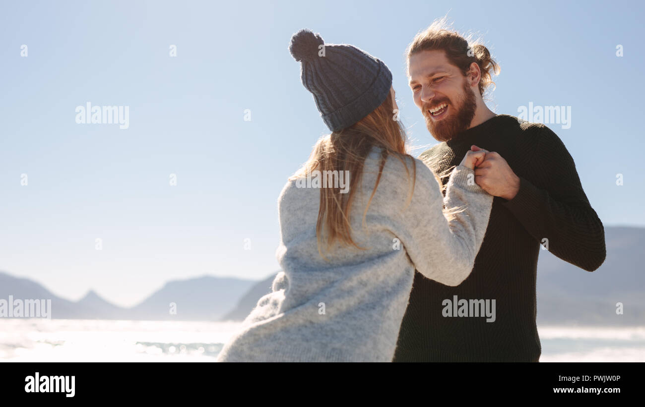 Coppia romantica davanti alla spiaggia. Giovane godendo di una spiaggia in una giornata di sole. Foto Stock