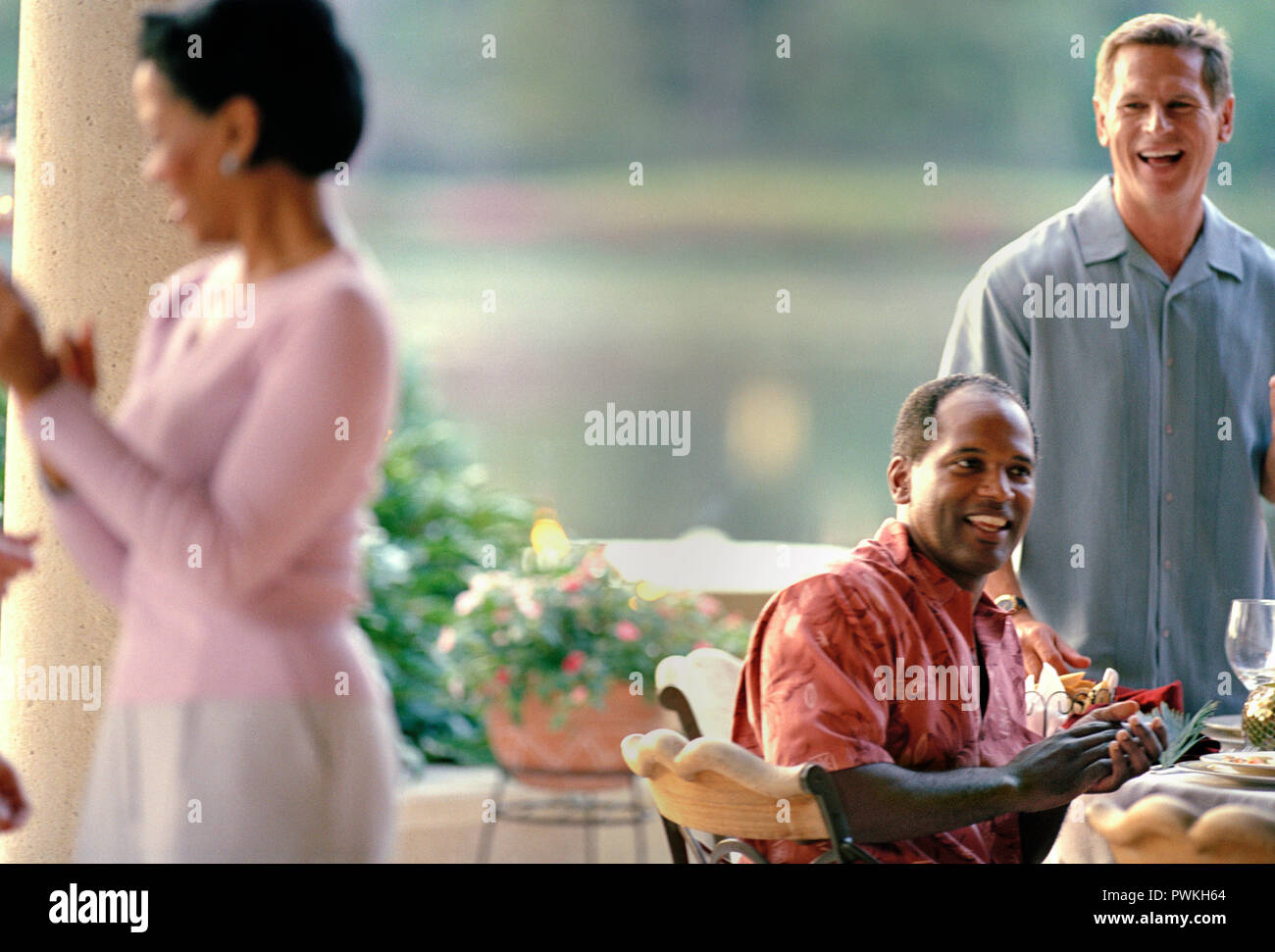 Due metà uomini adulti ridendo durante una cena all'aperto partito. Foto Stock