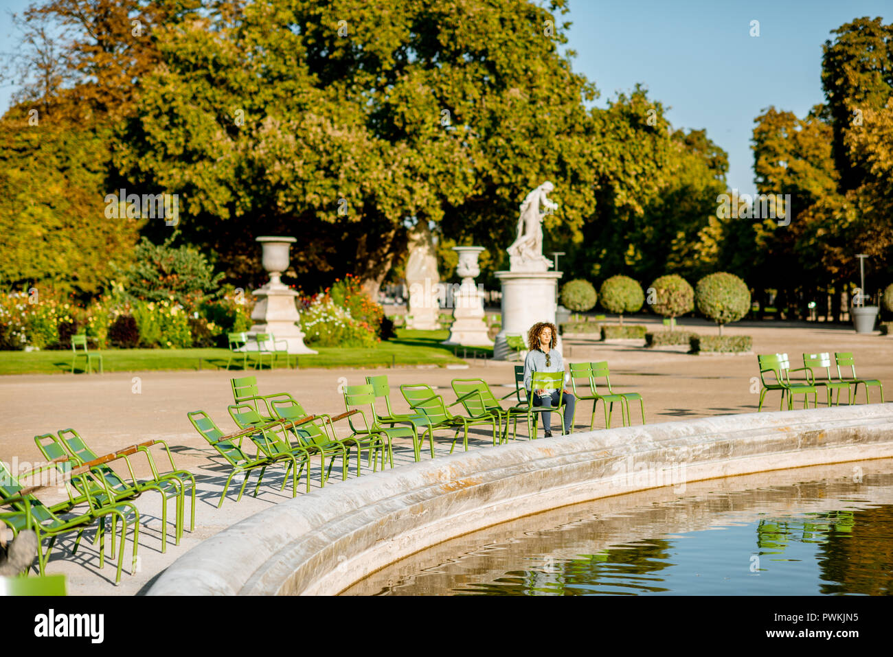 Parigi, Francia - 01 Settembre 2018: Donna seduta sulla famosa sedie verdi in Tuileries parco vicino alla fontana a Parigi Foto Stock