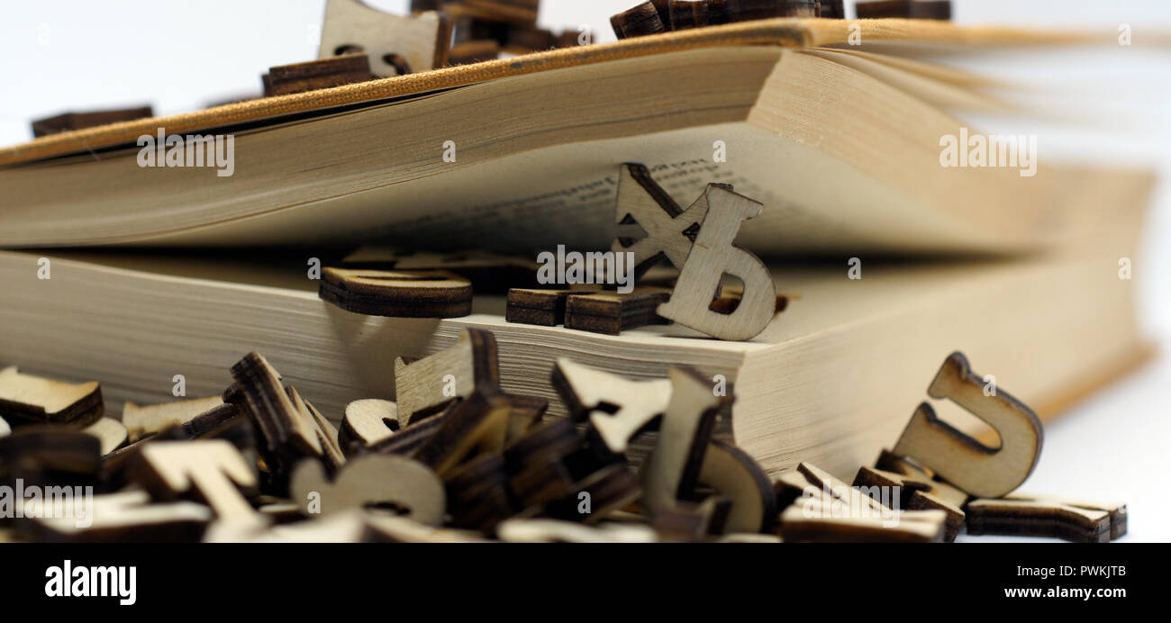 Vecchio libro con copertina rigida e la caduta di lettere Foto Stock