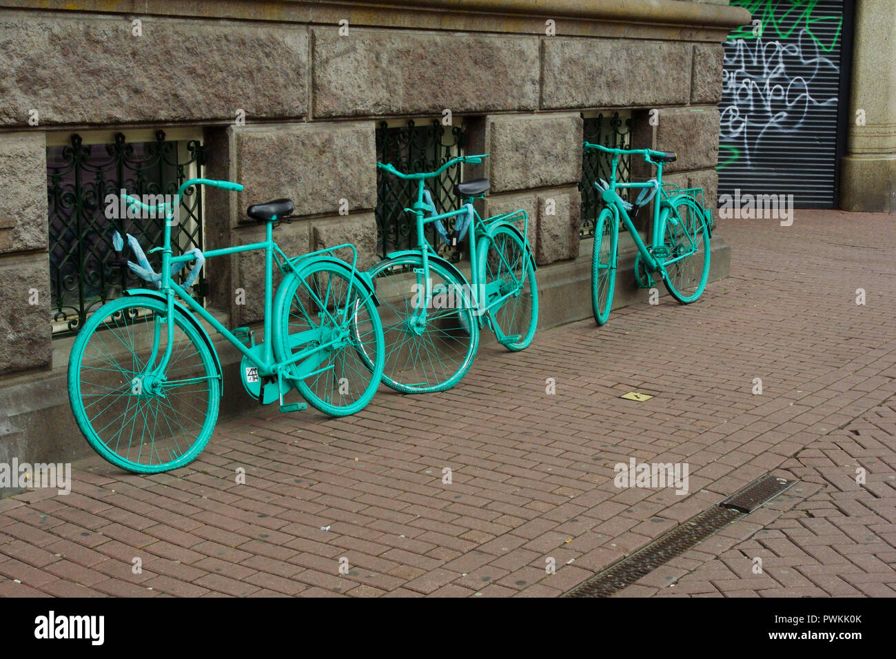 Dipinto di vecchie biciclette appoggiata dalla parete in Amsterdam Foto Stock