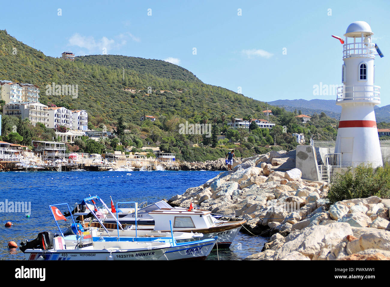 Il faro del porto. Kaş (pronunciato "Kash') è una piccola pesca, immersioni, vela e città turistica e un distretto della provincia di Antalya in Turchia, 168 km a ovest della città di Antalya. Come una località turistica, è relativamente incontaminata. Foto Stock