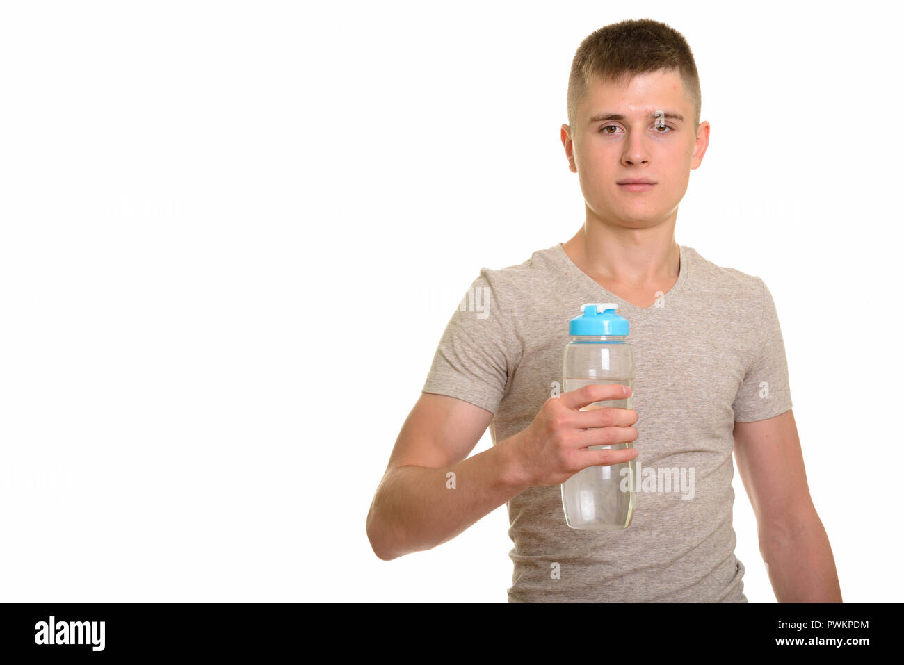 Giovane uomo caucasico tenendo la bottiglia di acqua e guardando la fotocamera Foto Stock