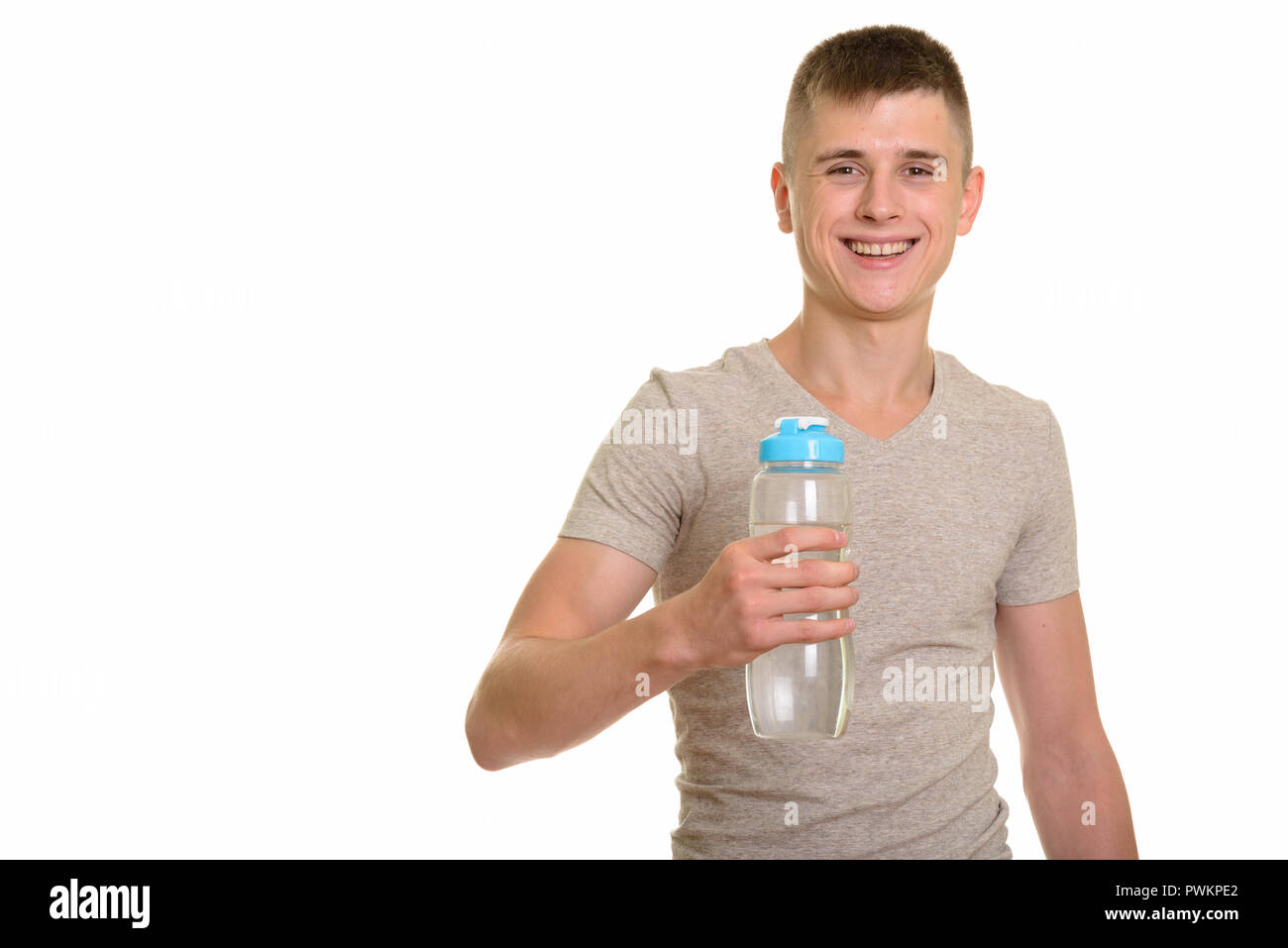 Felice giovane uomo caucasico sorridente e tenendo la bottiglia di acqua Foto Stock