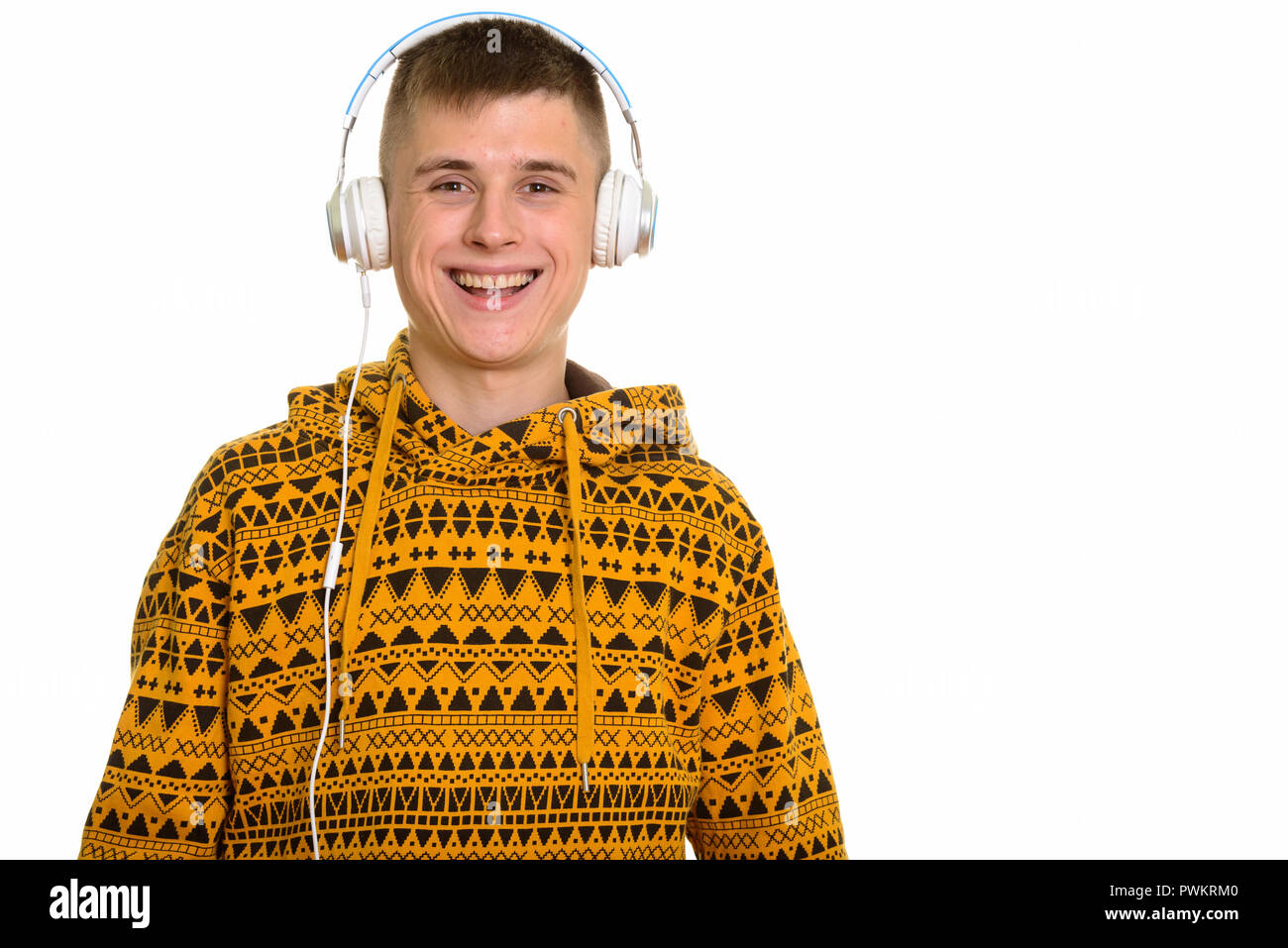 Giovani caucasici felice uomo sorridente mentre si ascolta la musica con le cuffie Foto Stock