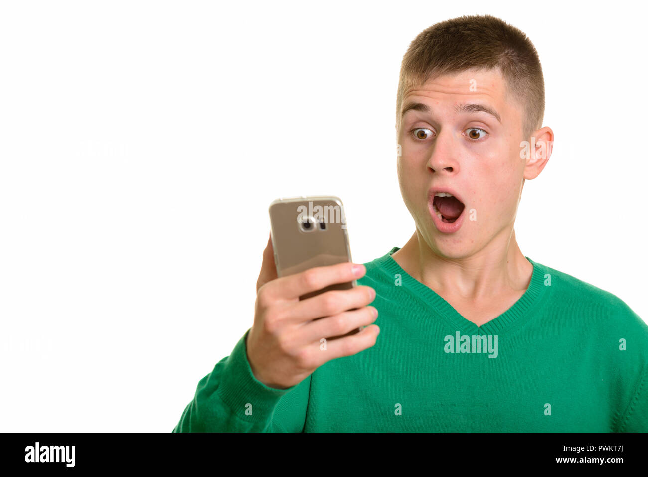 Giovane uomo caucasico tenendo il telefono cellulare cercando sorpreso Foto Stock