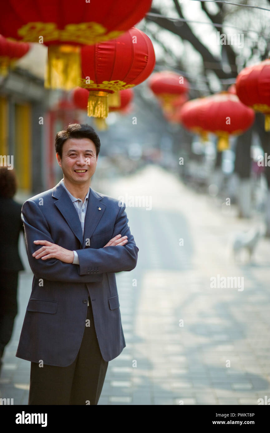 Ritratto di un sorridente giovane con le braccia incrociate. Foto Stock