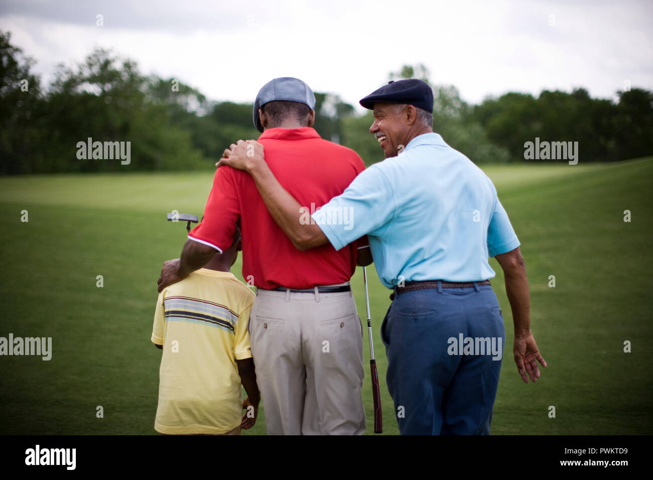 Ragazzo camminare sul campo da golf con il Padre e il Nonno Foto Stock