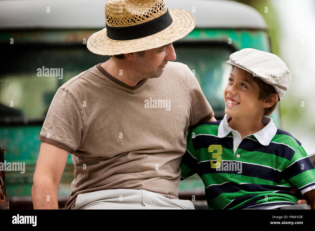 Padre e figlio seduti fianco a fianco. Foto Stock