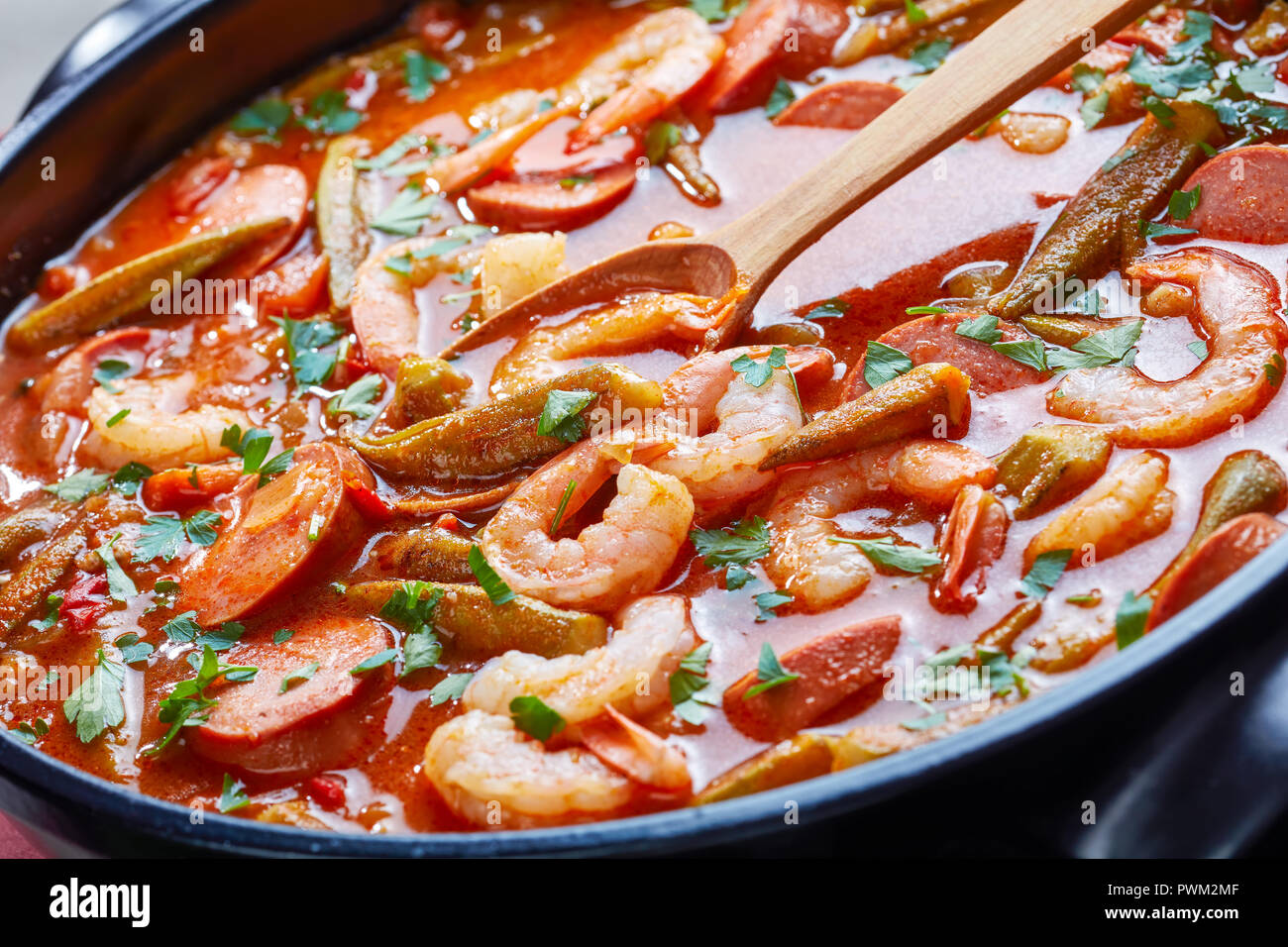 Gumbo deliziosi con gamberetti, okra e salsiccia in una ciotola, close-up Foto Stock