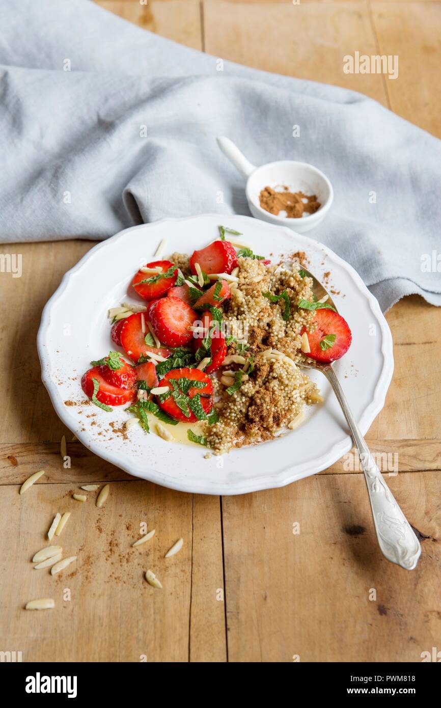 La quinoa porridge con fragole macinate e bastoncini di mandorle Foto Stock