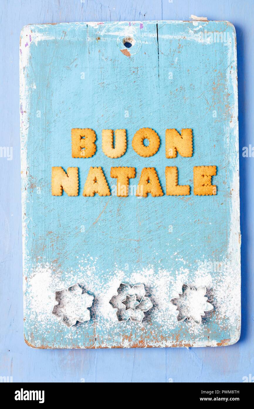 Auguri di Natale scritta con biscotti in italiano e coltelli Foto Stock