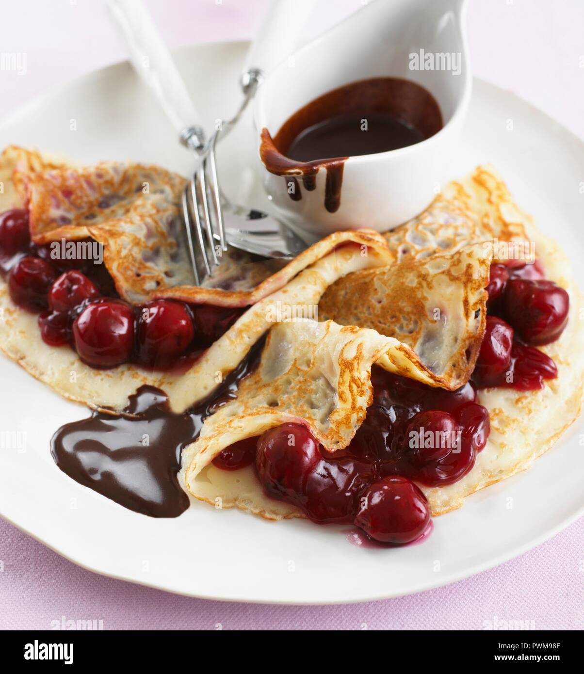 Frittelle con ciliegie e salsa al cioccolato Foto Stock