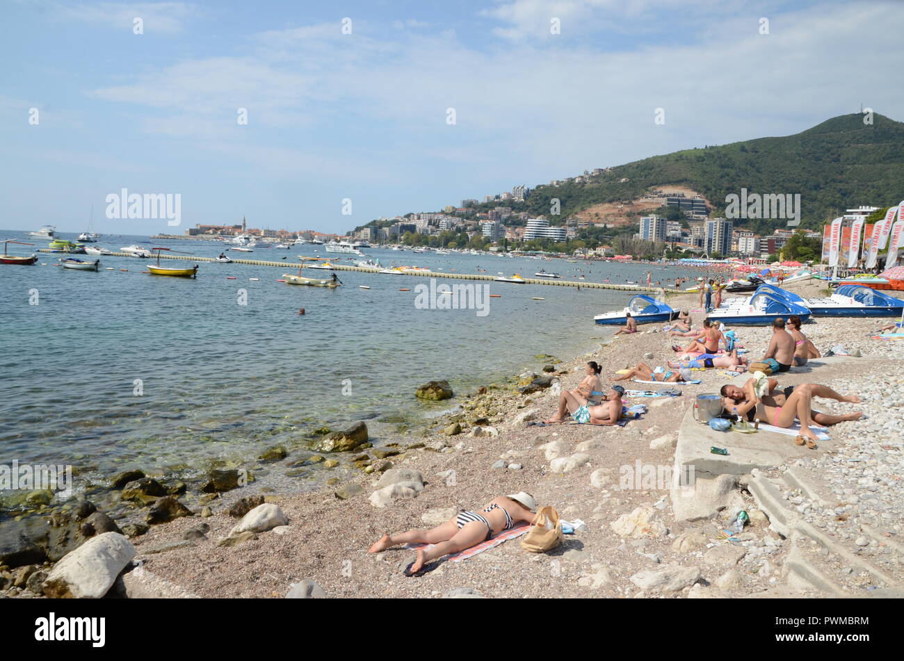La Budvar montenegro spiaggia con lucertole da mare e spazzatura Foto Stock