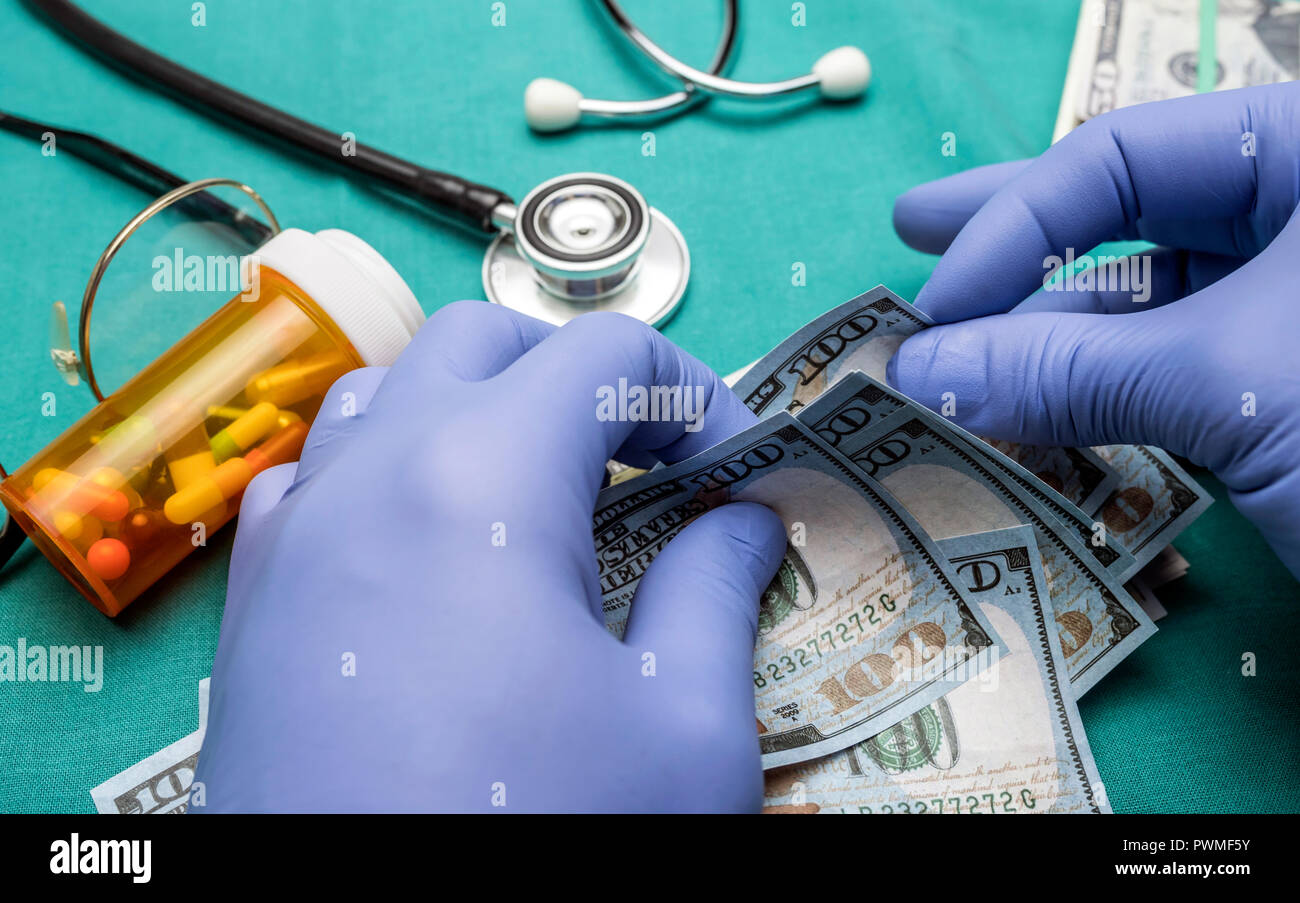 Medico con guanti in lattice blu a contare centinaia di fatture del dollaro in un ospedale Foto Stock