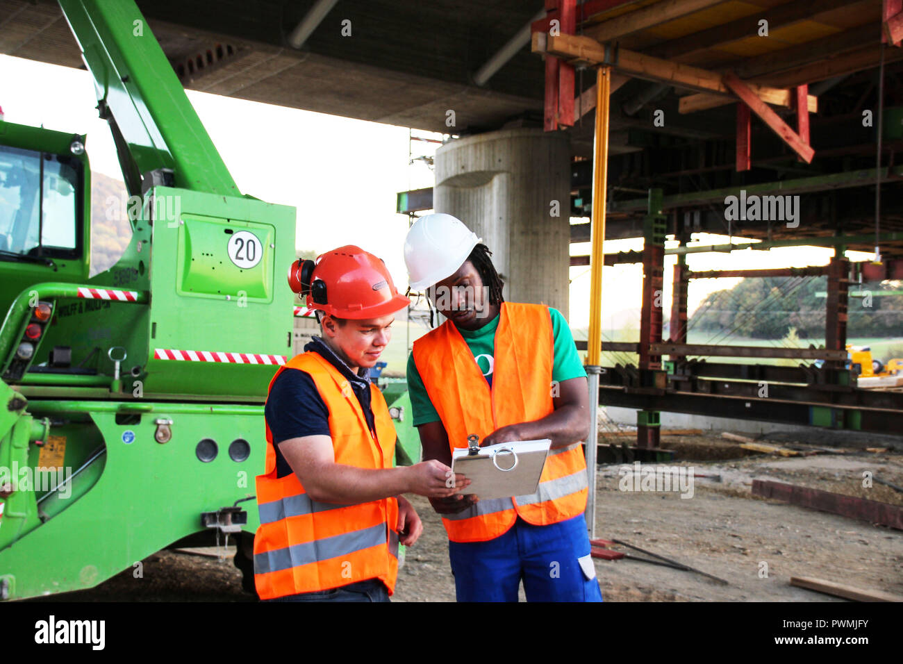 Due lavoratori edili osservando il piano del sito Foto Stock